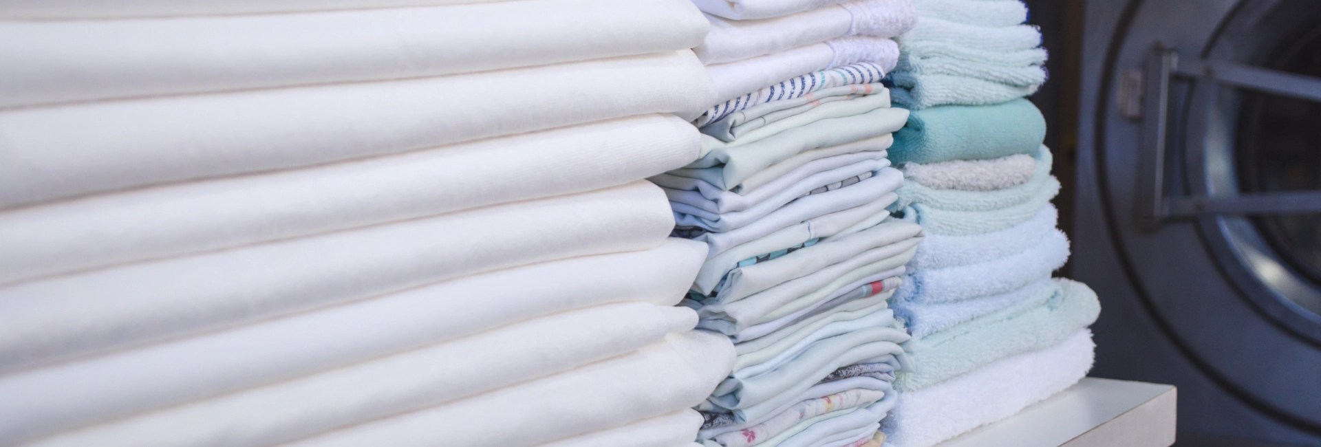 Stacks Of Linens And Clothes 1920X650